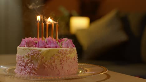 candles being blown out on party celebration cake for birthday decorated with icing on table at home 1