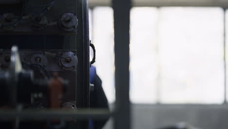 Close-up-tyre-manufacturing-process-with-worker-checking-at-industrial-factory