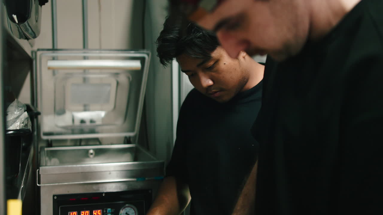 People using a vacuum sealer in a kitchen