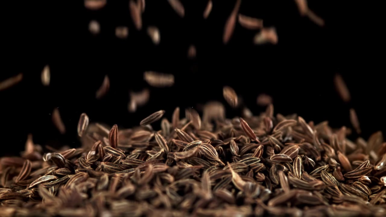 Cumin Seeds Falling in Slow Motion on Black Background