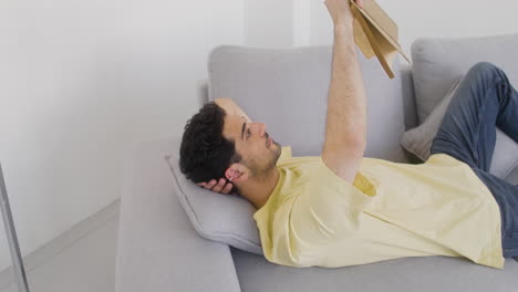 attractive man reading on a sofa