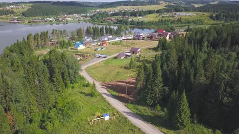 aerial view of a village by a lake with surrounding forest