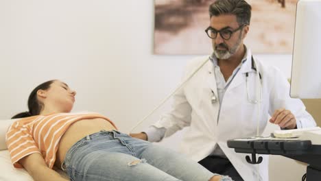 sonographer doing abdomen ultrasound examination of woman in hospital