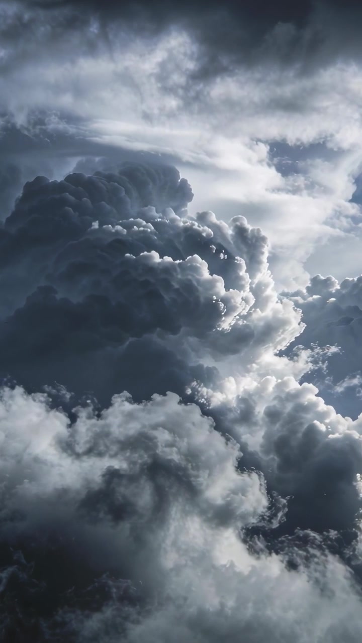 Vertikal video: Vippende kamera viser stormsky vokser over nederste dæk, sollys omkranser toppe.