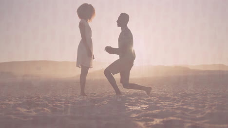 couple kneeling on beach at sunset, proposing with animated heart icon over ring box for marketing