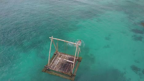 Vista-Aérea-De-Seguimiento-De-Una-Joven-Caucásica-En-Bikini-Nadando-Desde-Una-Balsa-De-Bambú-Flotante-En-Aguas-Turquesas-Claras-En-Las-Filipinas