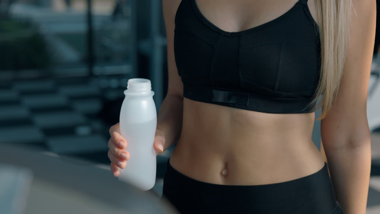 A person holding a water bottle in a gym