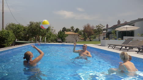 familia jugando con una pelota en la piscina