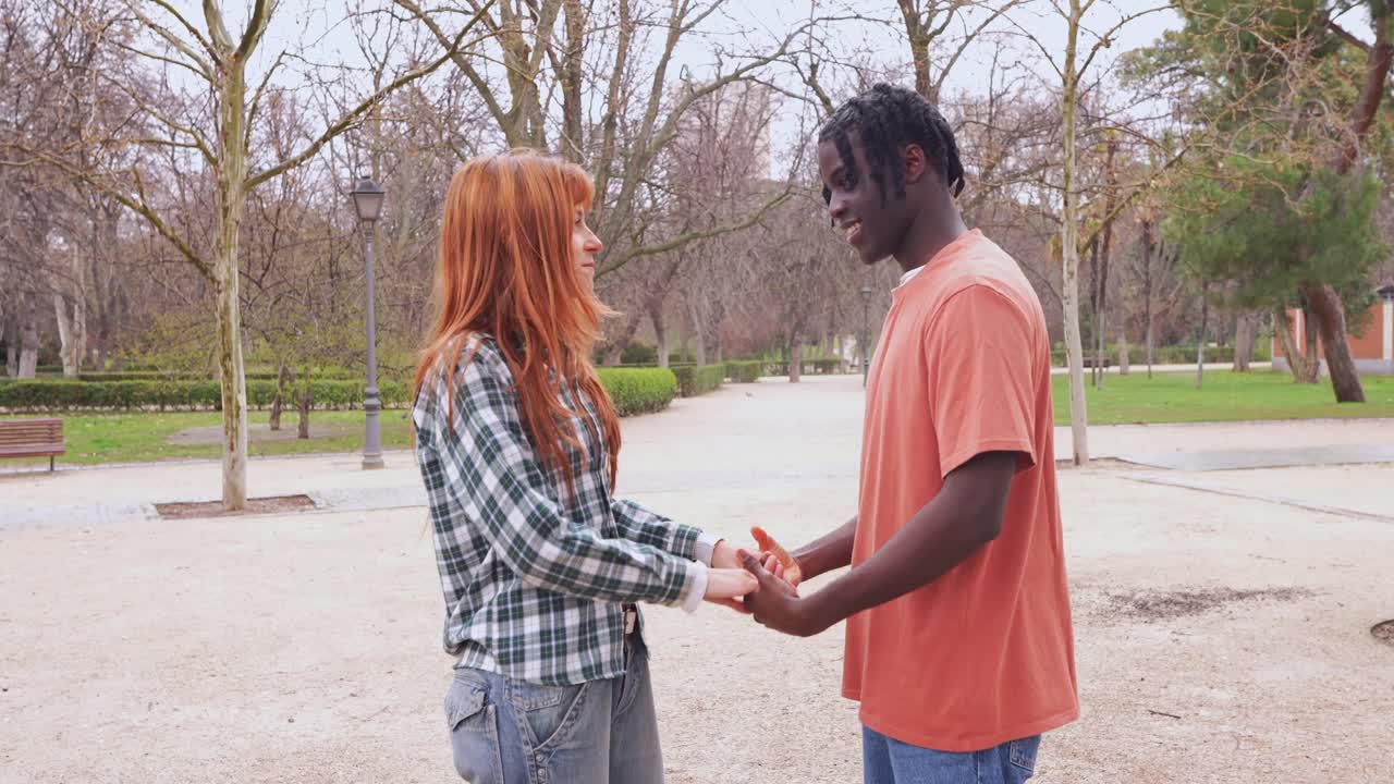 Interracial couple holding hands in a park