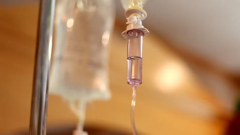 an iv bag hanging and dispensing medicine to a patient in a hospital room