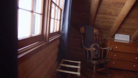 cozy log cabin interior pan to reveal rocking chair and window with light rays