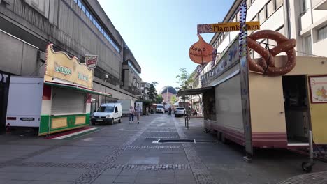 early morning in darmstadt in shopping district with food trucks and passerby people. hessen. germany