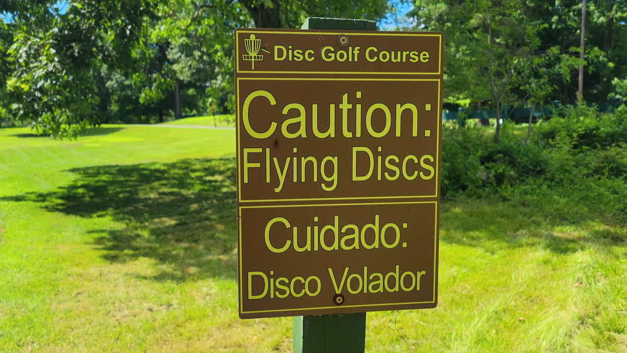 cerca de una señal de precaución en un campo de disc golf