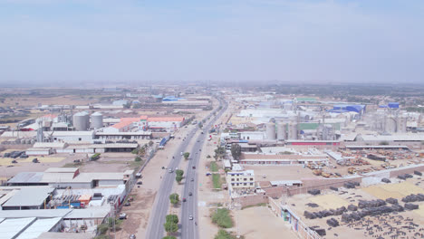 Amazing-aerial-zoom-in-shot-with-drone-of-the-famous-Peruvian-highway-"Panamericana-Norte"-with-houses-in-the-background-in-the-city