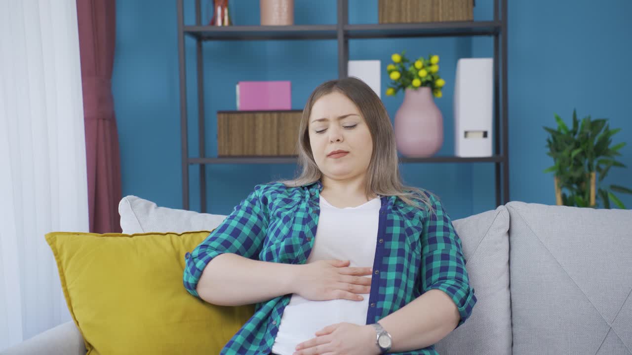 mujer joven con dolor de estómago.