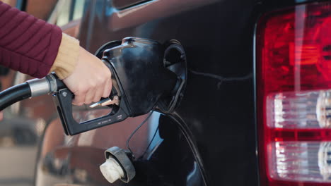 echando gasolina a un coche negro