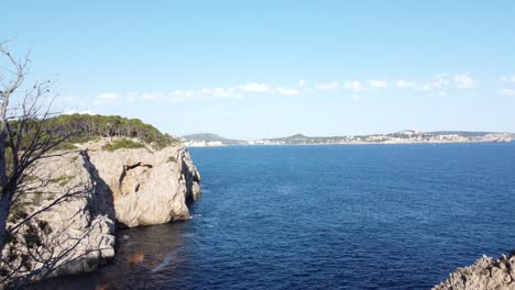 mallorca coast line view from a steady floating drone onto the shore and cliffs on a bright summer day