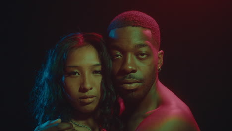 young loving couple posing under neon light