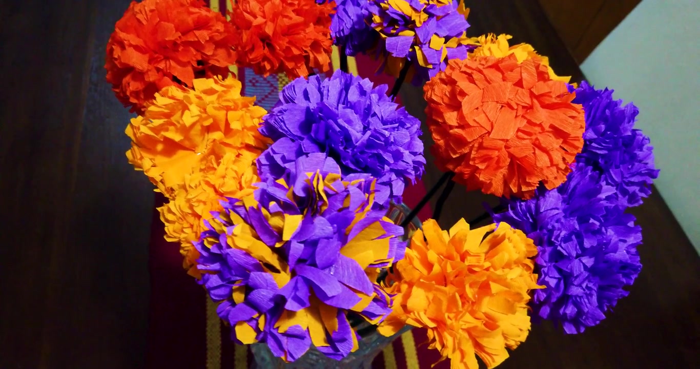 Ripresa orbitale di fiori di Cempasúchil fatti di carta crespa, parte della decorazione e dell'ofrenda nella celebrazione del Giorno dei Morti in Messico