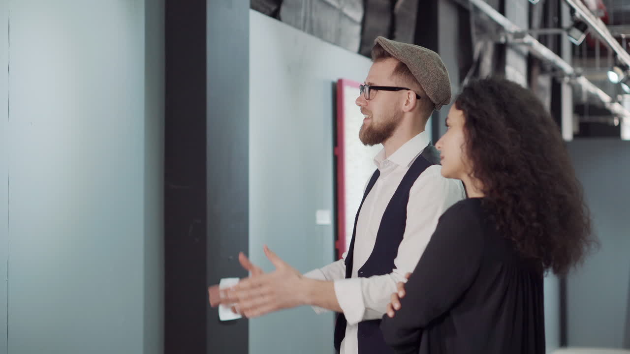 una pareja observando el arte en una galería.