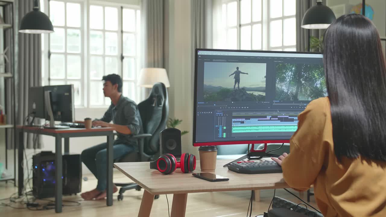 Back View Of Asian Female Video Editor Celebrating While Works With Footage And Sound On Her Personal Computer In Office