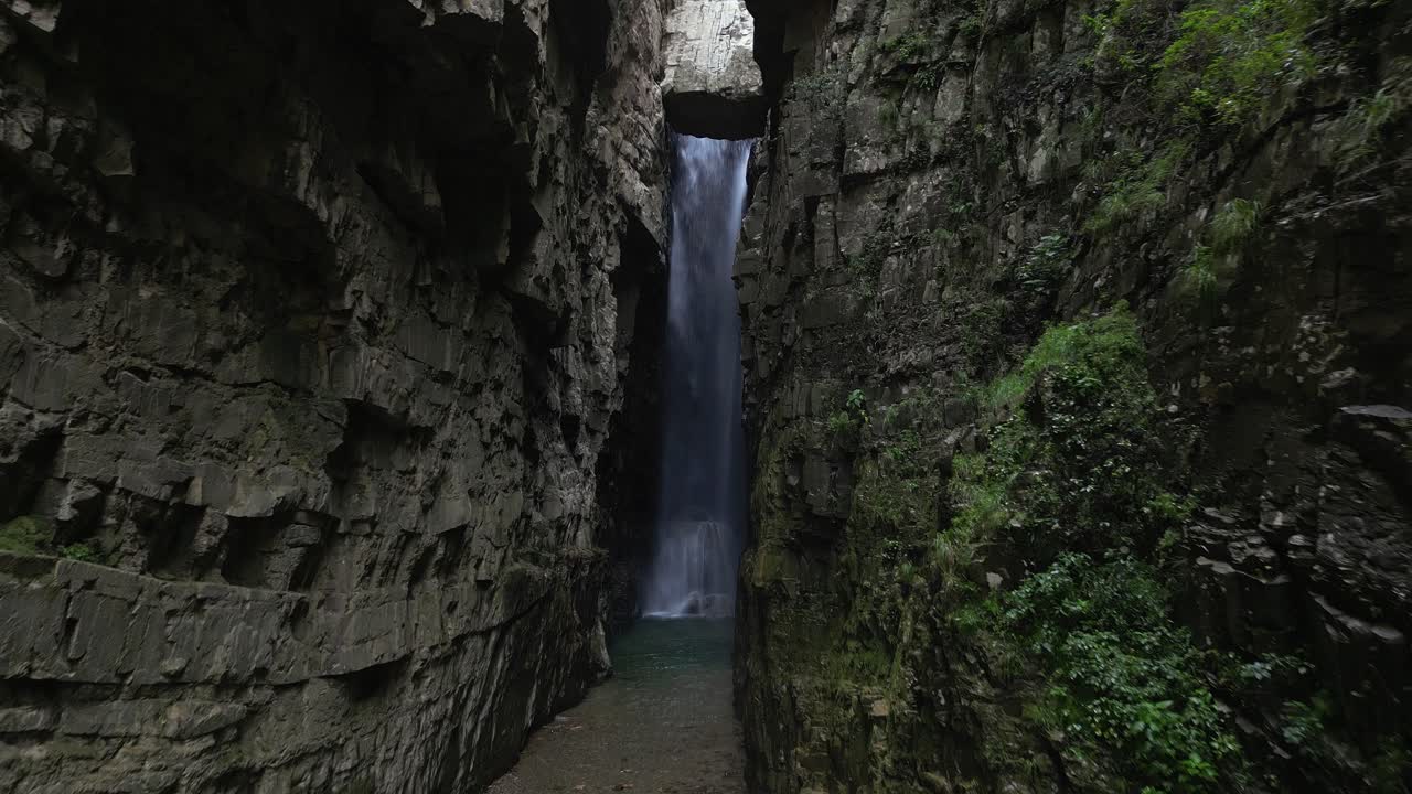 큰 폭포를 향해 은 바위 절벽 사이에서 기운이 어두운 비행