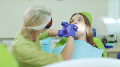 young woman with open mouth during dental procedure