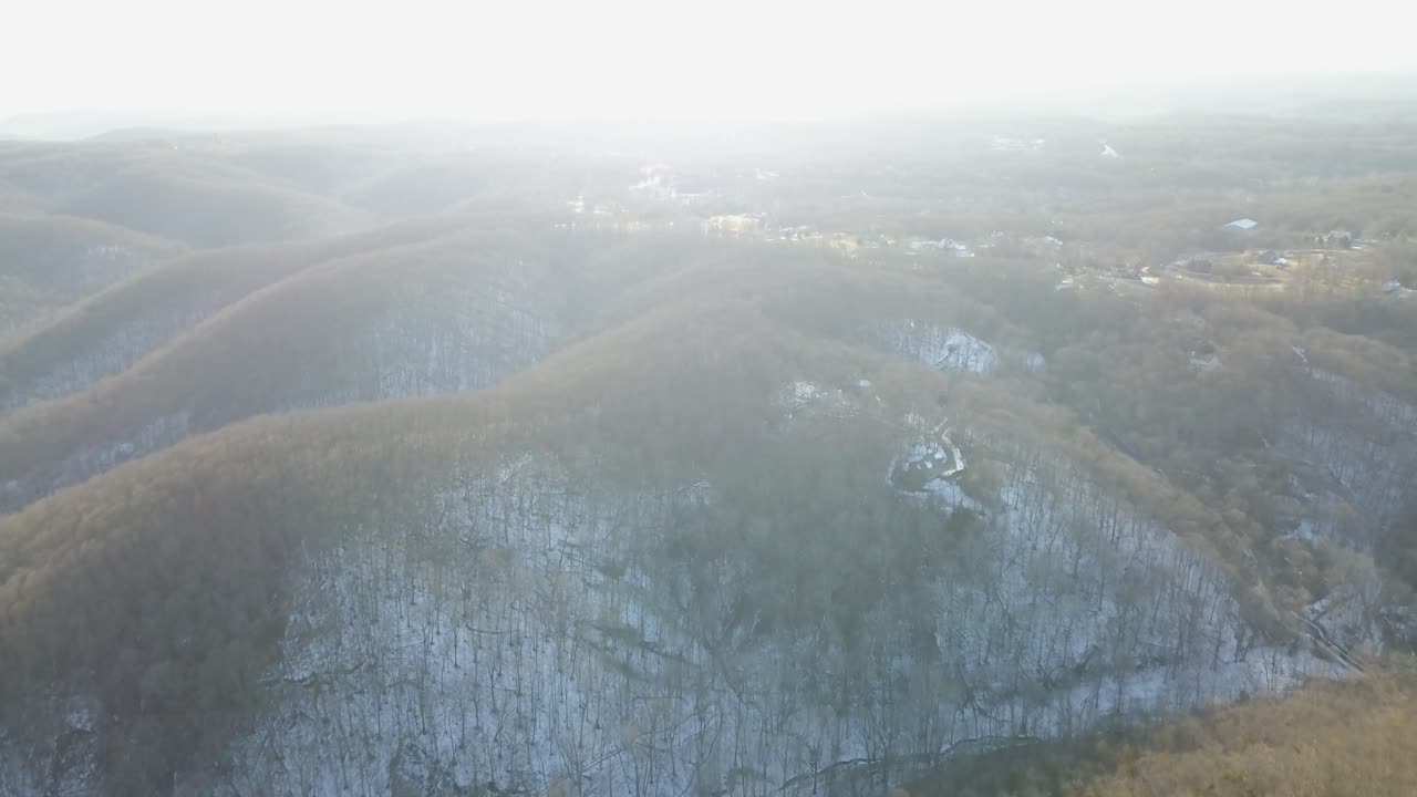 Aerial View of Snow Covered Hills and Forest in Winter