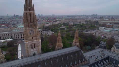 Aerial-shot-above-a-church-with-a-tower-in-downtown-Vienna,-Austria