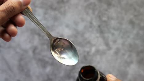 measuring medicine dosage with a spoon