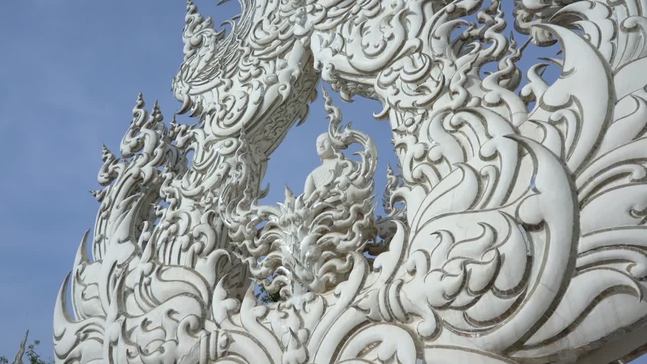 Buddha statue surrounded by beautiful ornaments at White Temple, Thailand.