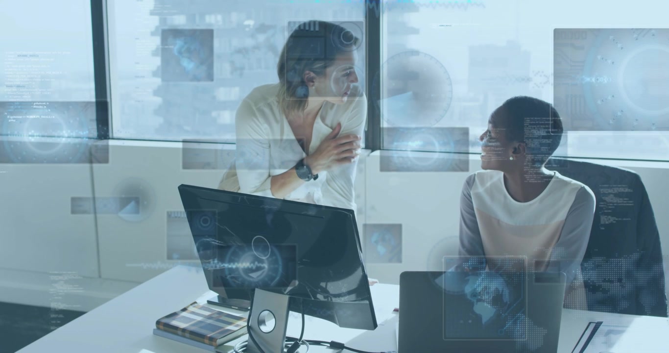 Coworkers leaning on desk reviewing monitor causing holographic charts and maps for data analysis