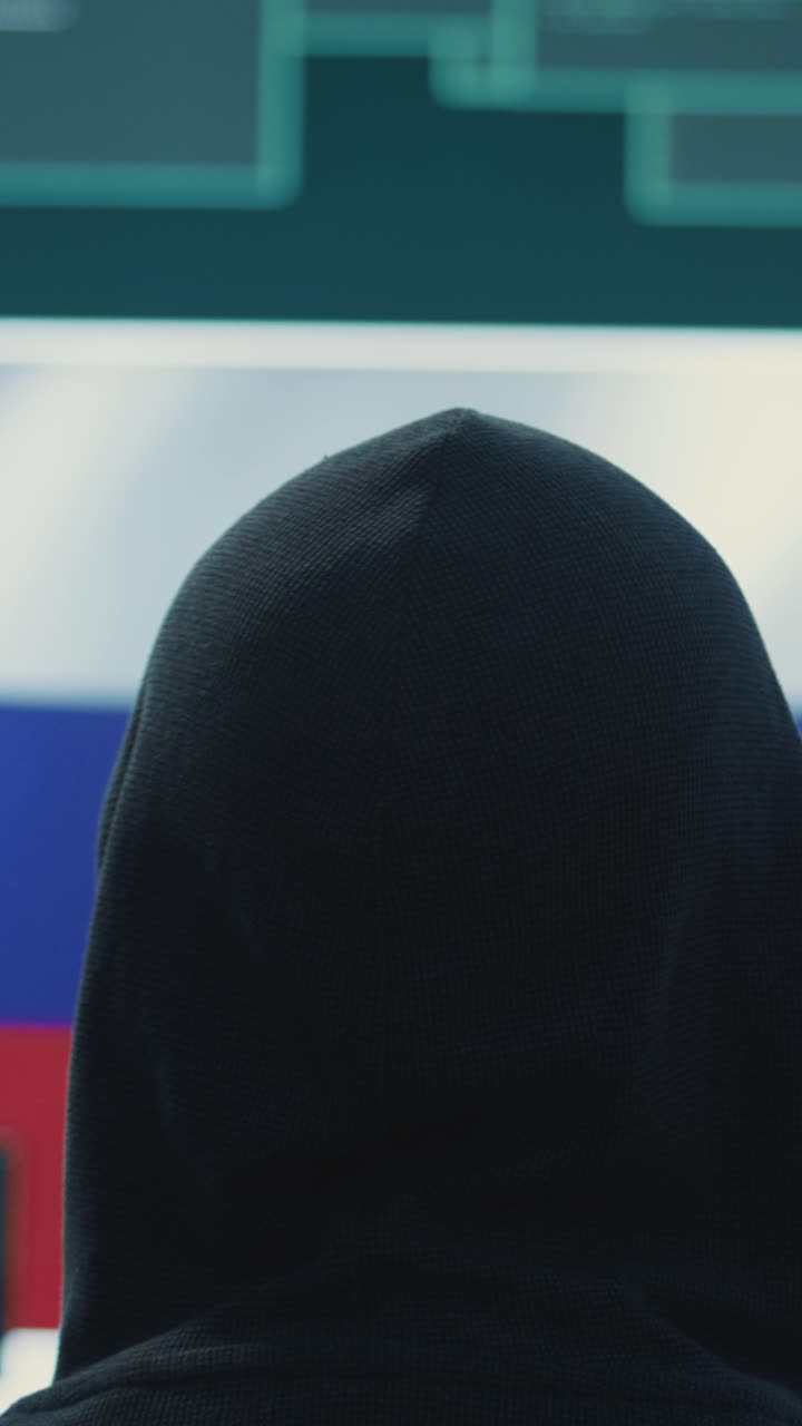Hacker anonimo che lavora davanti alla bandiera russa