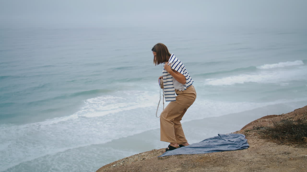 여름 주말에 여성 휴식 바다 피크닉 수직. 해변을 떠나는 무관심한 소녀