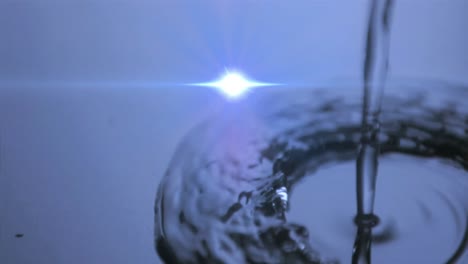 animación de gotas de agua cayendo en agua azul con luz brillante