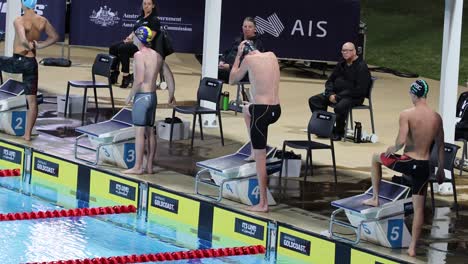 athletes readying at starting blocks by poolside