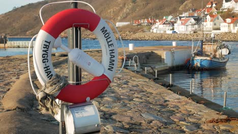 Molle-Hafen---Mölle-Hamm-Und-Trygg-hamn-Aufgedruckt-Auf-Rettungsring,-Der-An-Einem-Hafenpfosten-In-Molle,-Schweden,-Aufgehängt-Ist