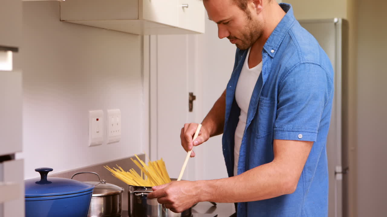 Uomo sorridente che mette la pasta in una pentola