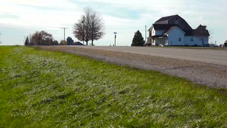 a pickup truck passes on a rural farm road in the midwest