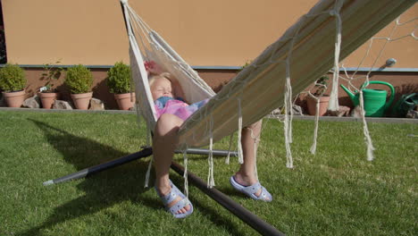 six-year-old girl squinting in hammock outdoors