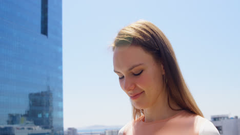 Side-view-of-young-caucasian-businesswoman-looking-down-and-standing-in-office-balcony-4k