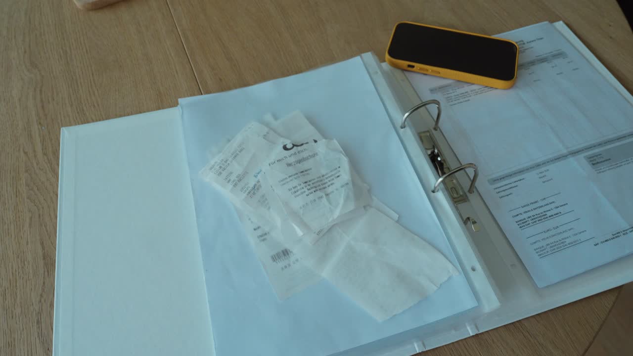 Hands placing receipts into a folder, representing organization, expense tracking, and document management