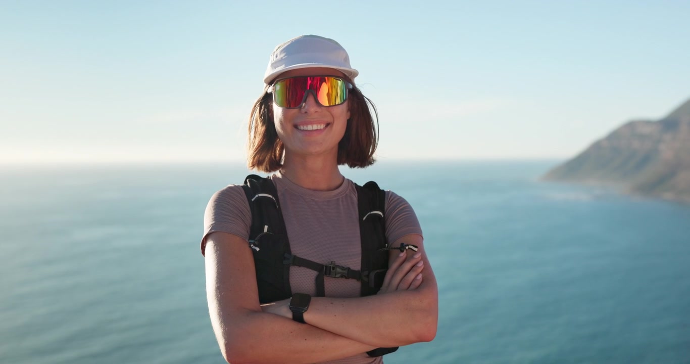 Smiling Female Hiker Standing on Coastal Cliff at Sunset