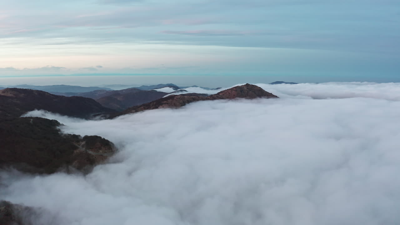 새벽에 안개가 가득한 산과 두꺼운 구름의 담요가 계곡을 가로질러 굴러가며 평온하고 장엄합니다.