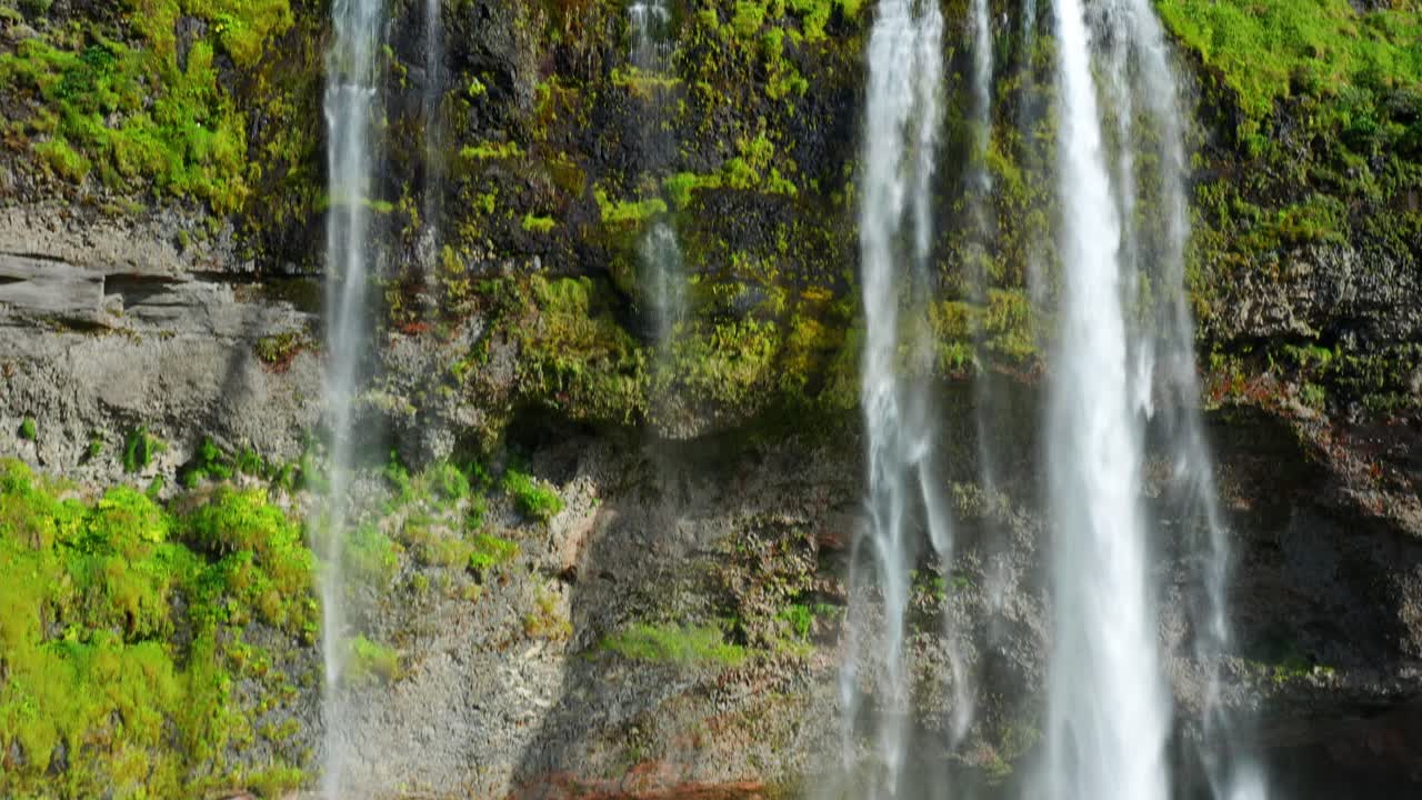 seljalandsfoss cascada glaciar agua de deshielo que fluye en el acantilado cubierto de musgo en islandia