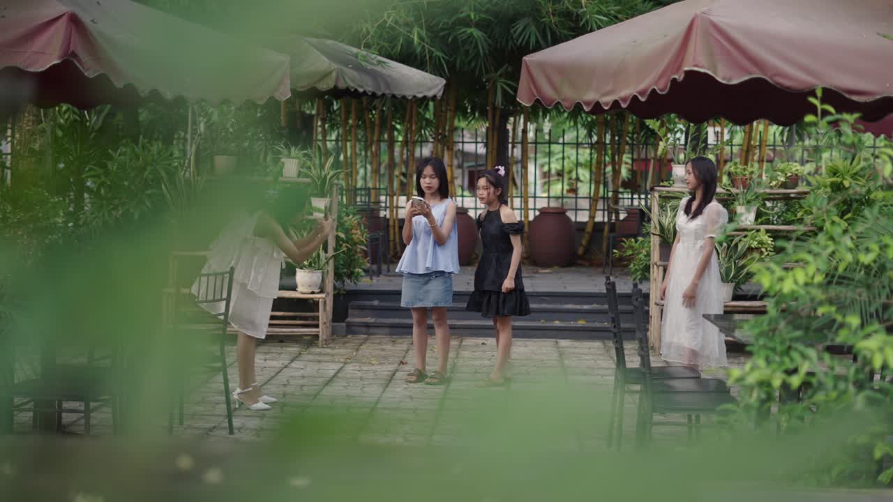 Girls Taking Photos in a Garden Cafe