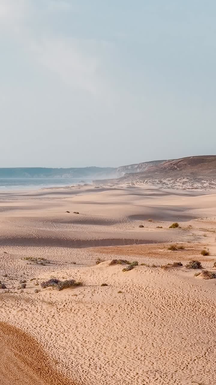 En gåtur på sandstranden i Portugal i det sene eftermiddagslys