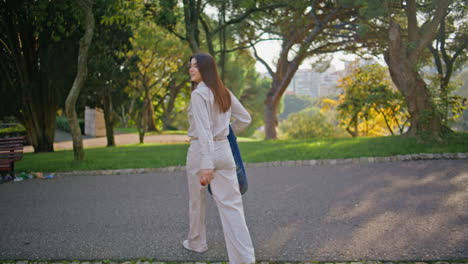 mujer cruzando el camino del parque hermoso fin de semana de verano. chica feliz disfrutar de un paseo