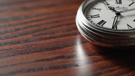 close-up of a vintage pocket watch on a wooden surface