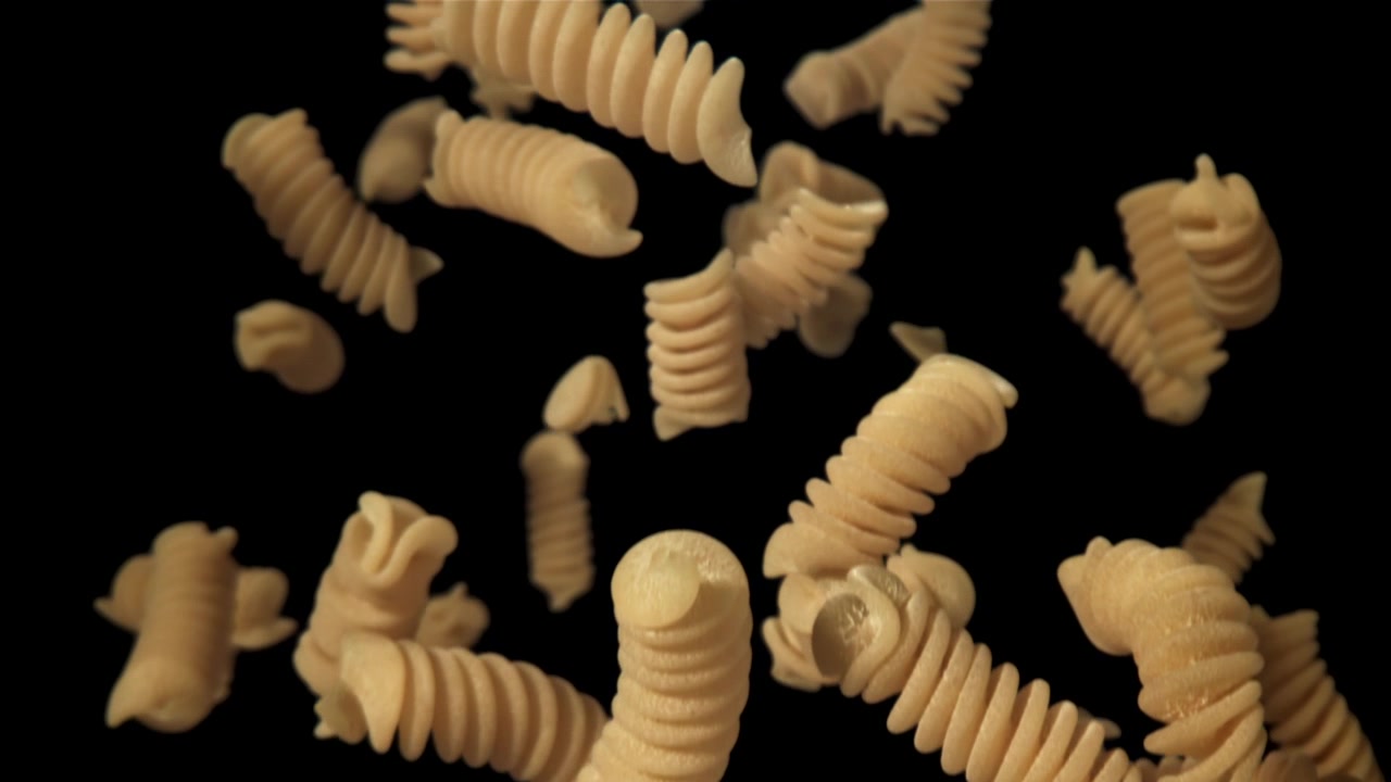 Pasta fusilli secca che cade e risale al rallentatore